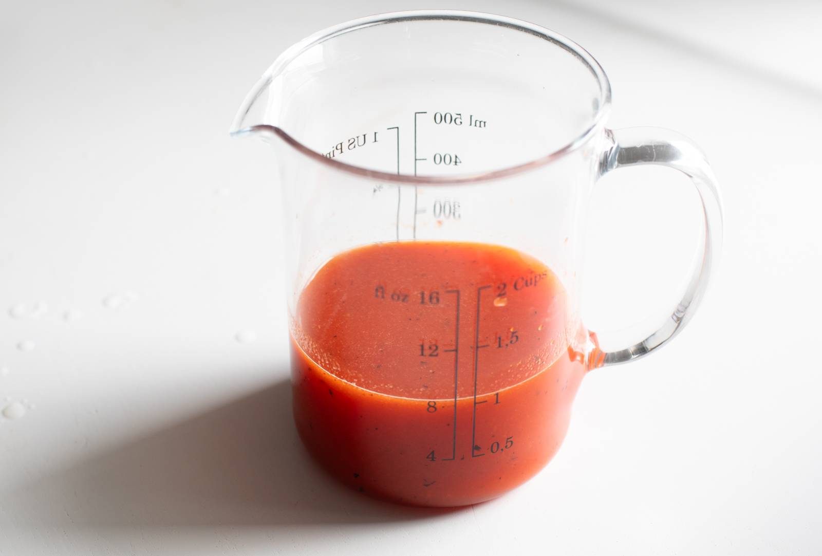 Red pepper puree in a measuring cup.