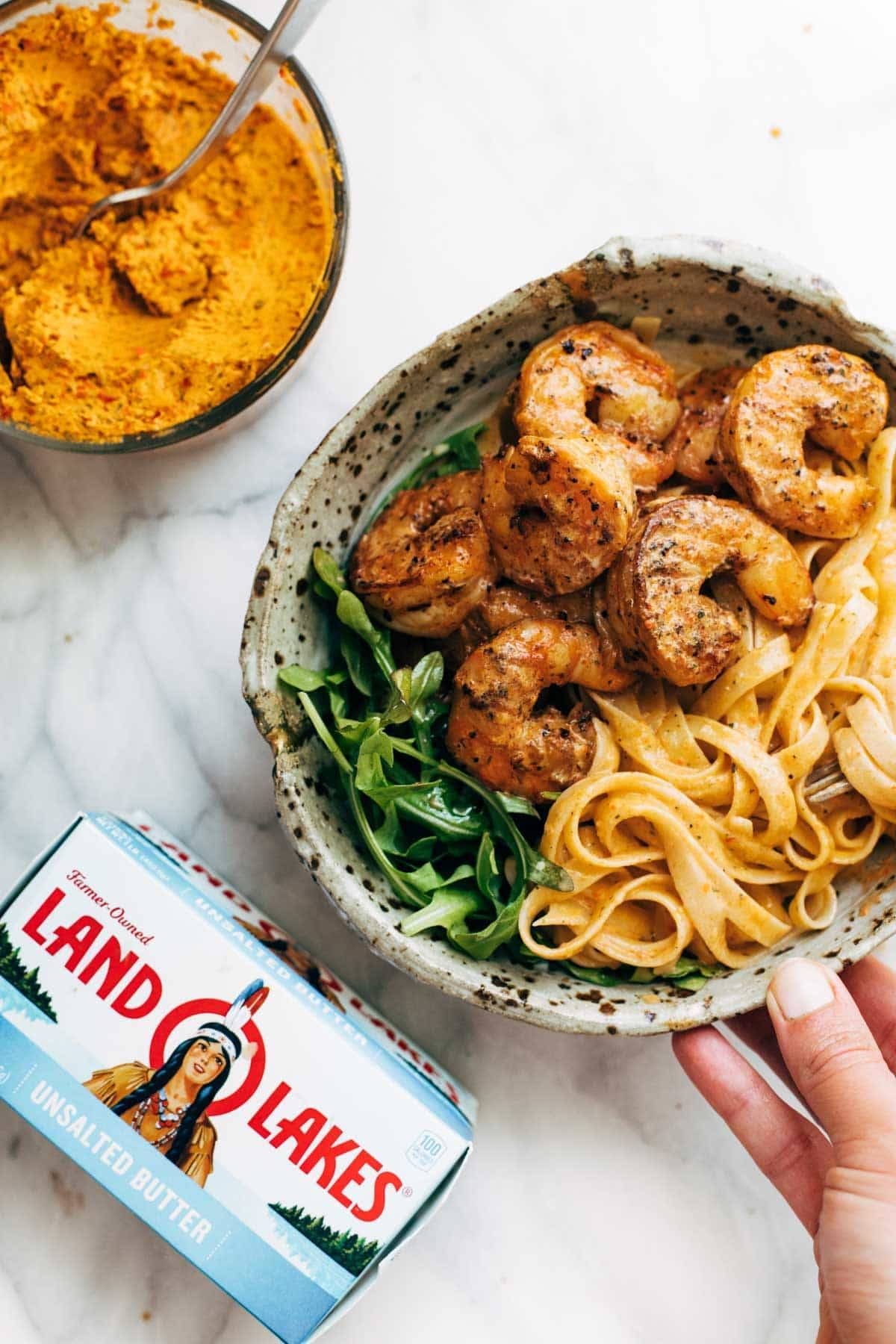 Red Pepper Fettuccine with Shrimp in a bowl with butter.