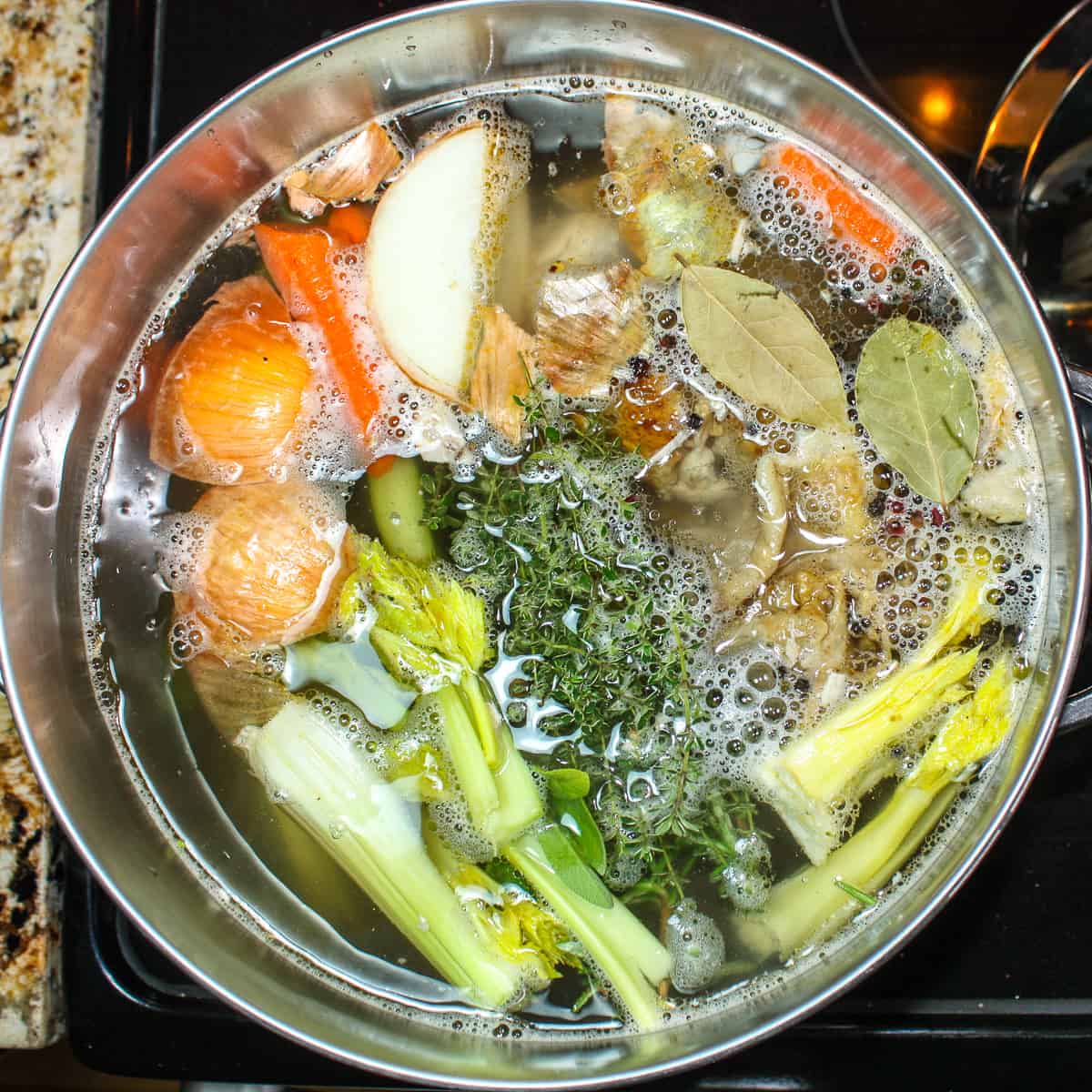 Ingredients to make homemade chicken stock in a soup pot.