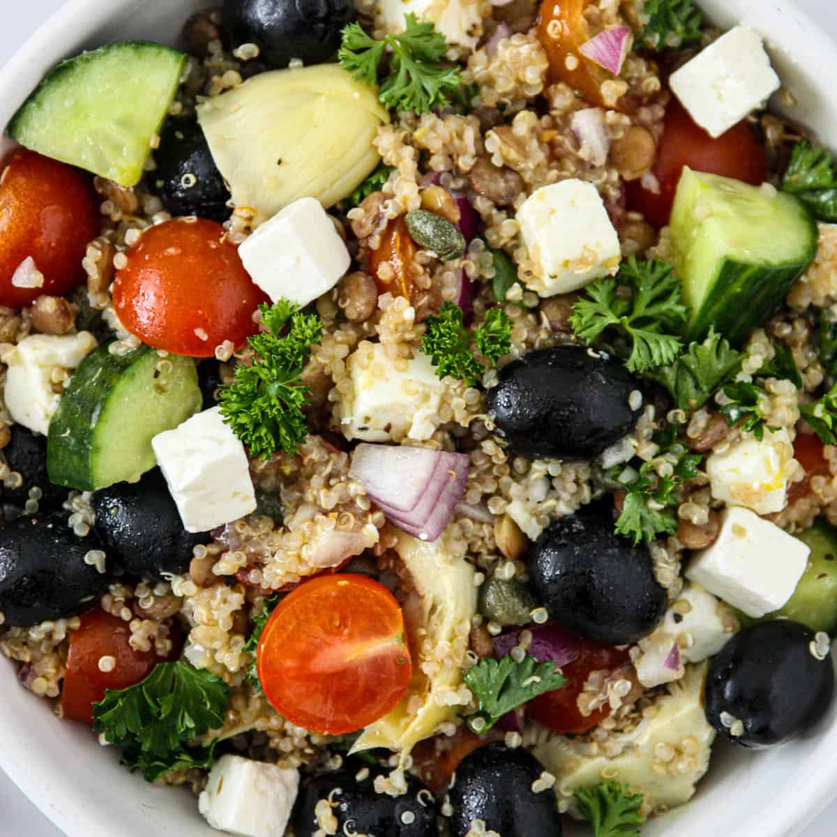 Quinoa and lentil salad with olives, cucumbers, and tomatoes.