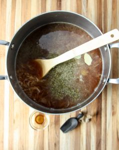 Broth and seasonings being added to the soup pot.