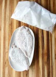 Chicken breasts coated in flour.