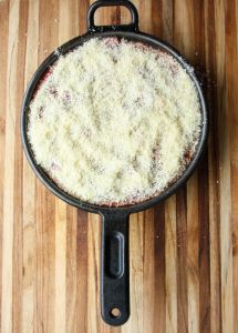 Chicken parmesan in a cast iron skillet covered in cheese.