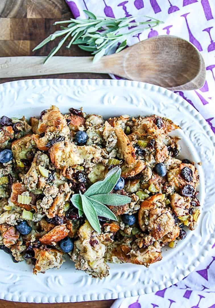 A plate of food on a table, with blueberries and Sausage