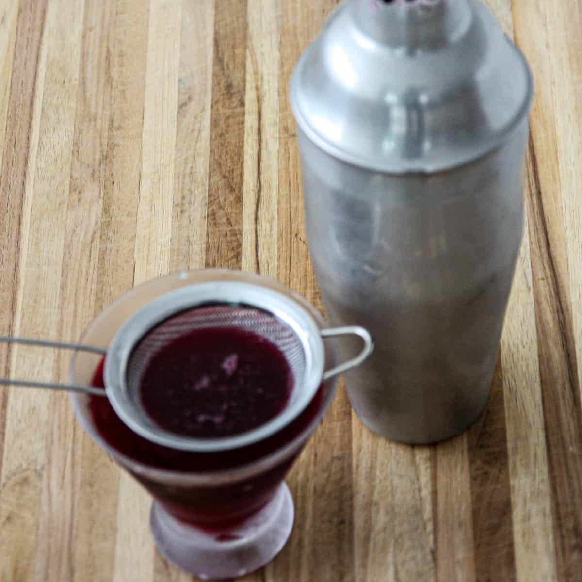 A fine mesh strainer over a martini glass.