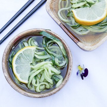 A close up of food on a table, with cucumber and lemon