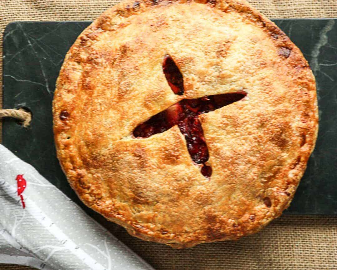 A pie sitting on top of a wooden cutting board