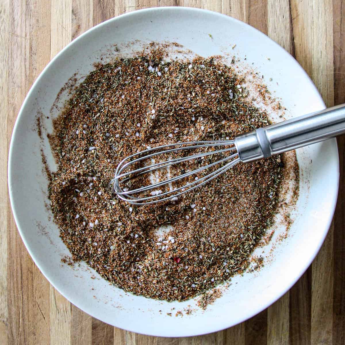The ingredients for Cajun spice mix whisked together on a white plate.