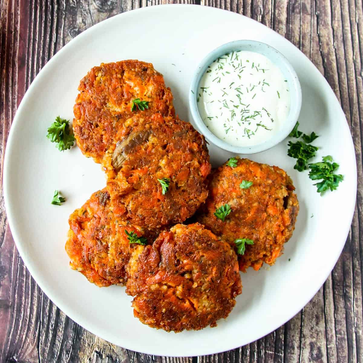 Several salmon patties on a white plate.