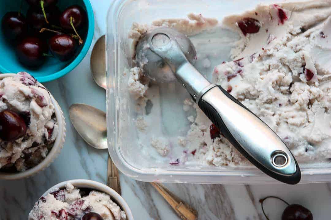 Ice cream being scooped out of a tub into bowls