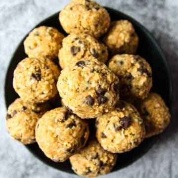 A black dish filled with ball-shaped oatmeal bites.