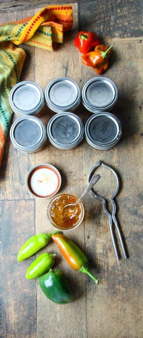 A wooden table topped with jars of jelly