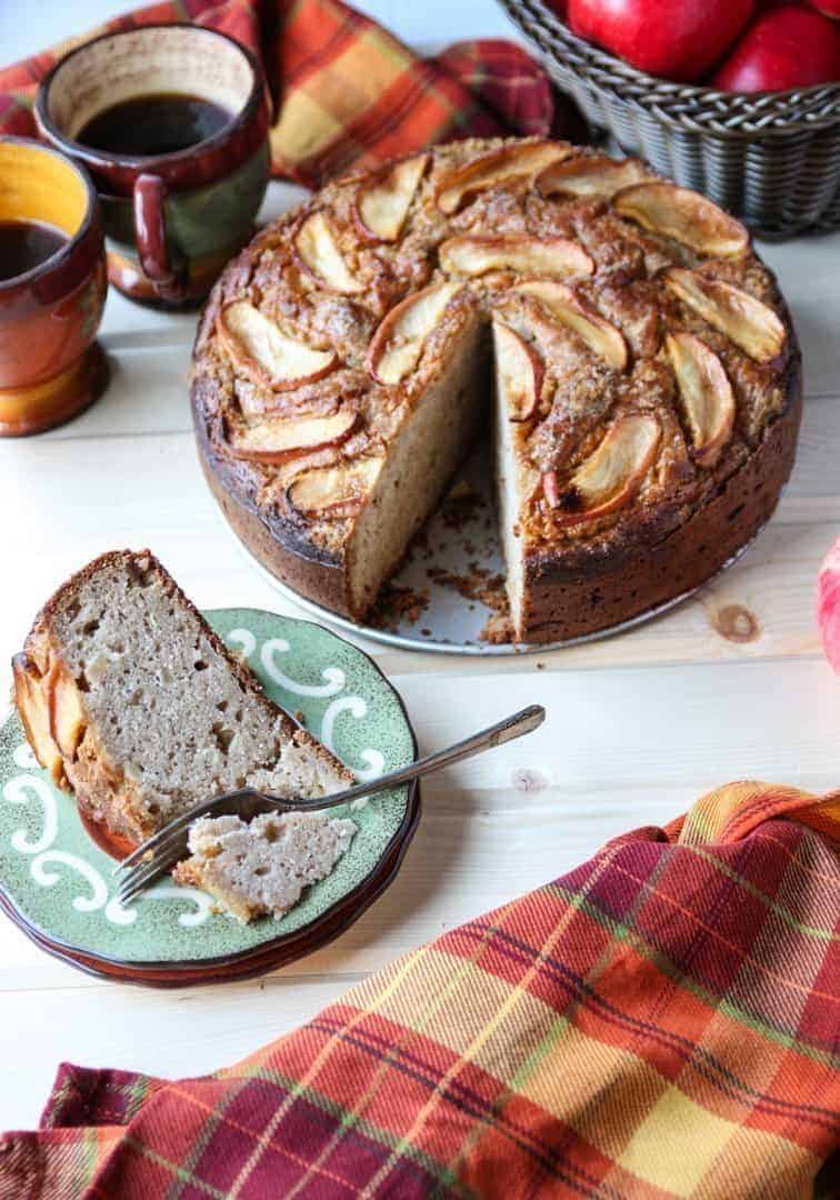 A cake on a table, with a slice of cake on a plate