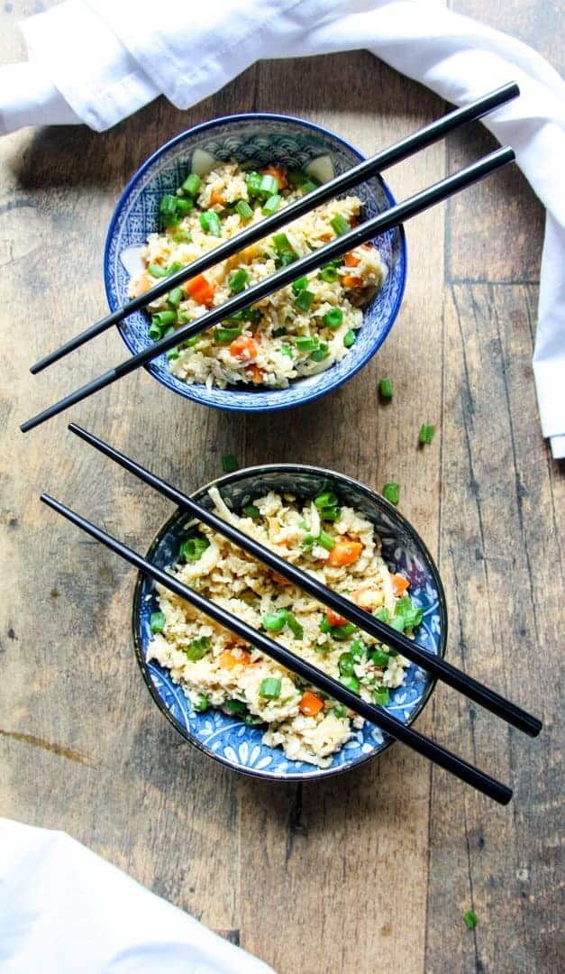 two blue & white bowls of cauliflower rice with black chopsticks