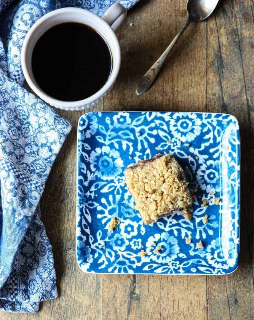 Matrimonial cake on a blue and white plate with a cup of coffee