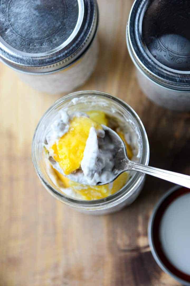A close up of a half-empty jar of fruit and pudding