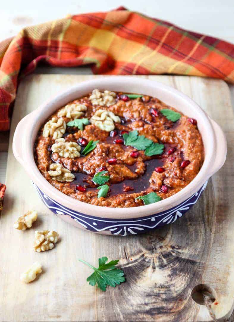 A bowl of dip on a cutting board