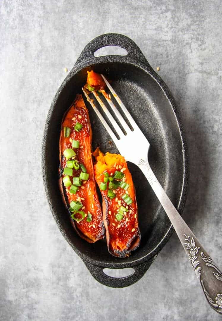 Baked miso sweet potatoes in a pan with a fork.