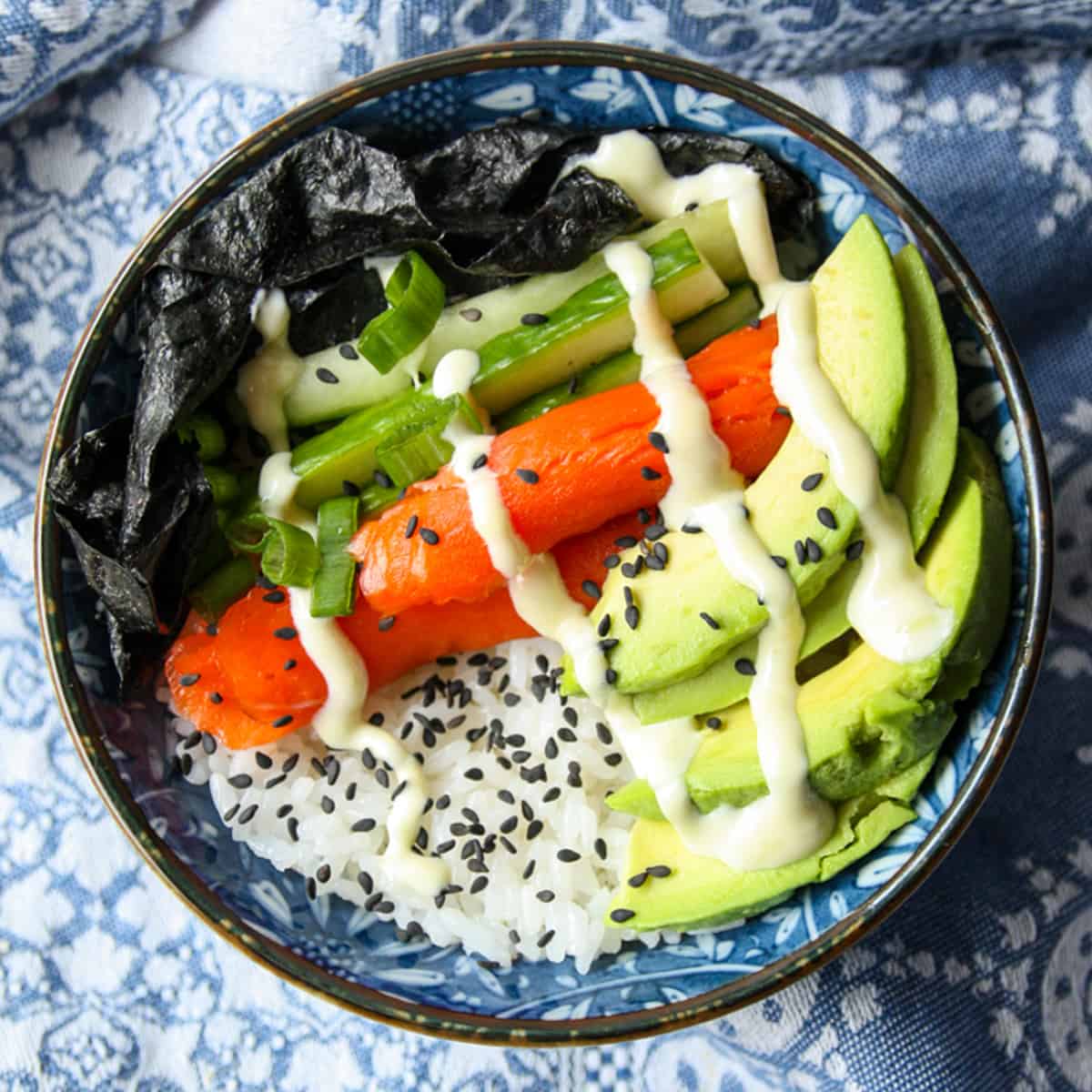 A salmon sushi bowl with avocado and cucumber.
