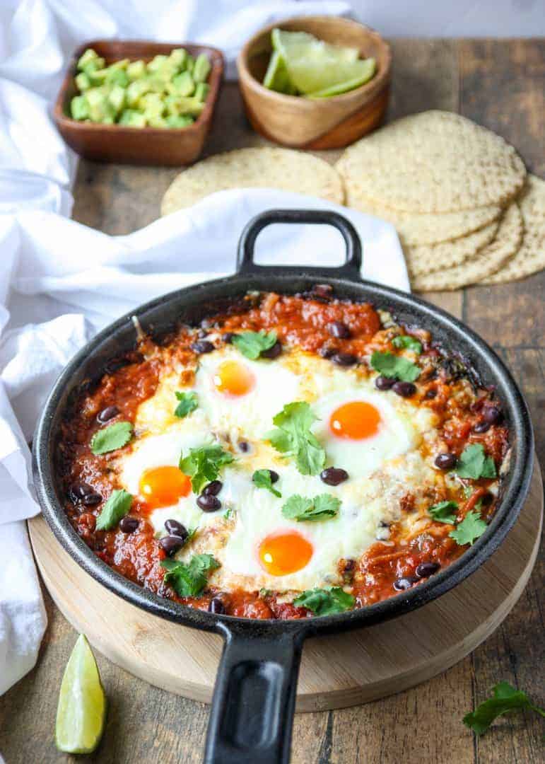 Top shot of a black skillet filled with baked huevos rancheros.