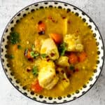 Turkey lentil soup in a black and white bowl.