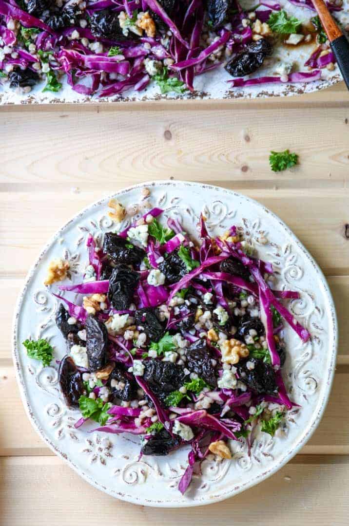 A white plate of buckwheat, prune, & red cabbage salad