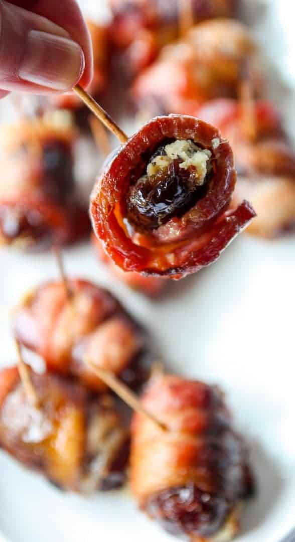 Close up of a bacon wrapped date appetizer on a toothpick