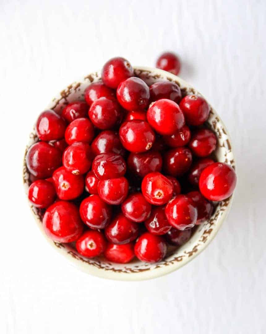 A bowl of cranberries on a table