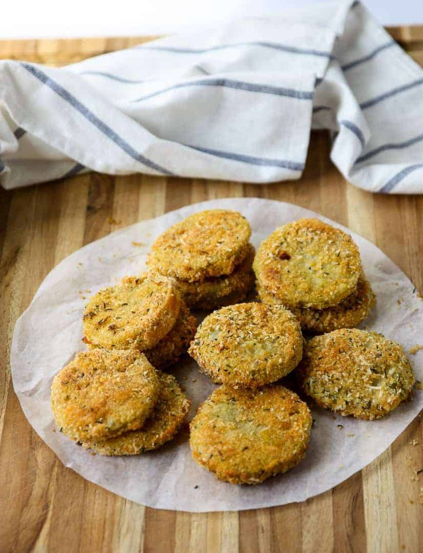 Fried green tomatoes on parchment paper on a wooden table