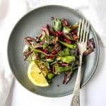 Sautéed Beet Greens on a black plate with a fork
