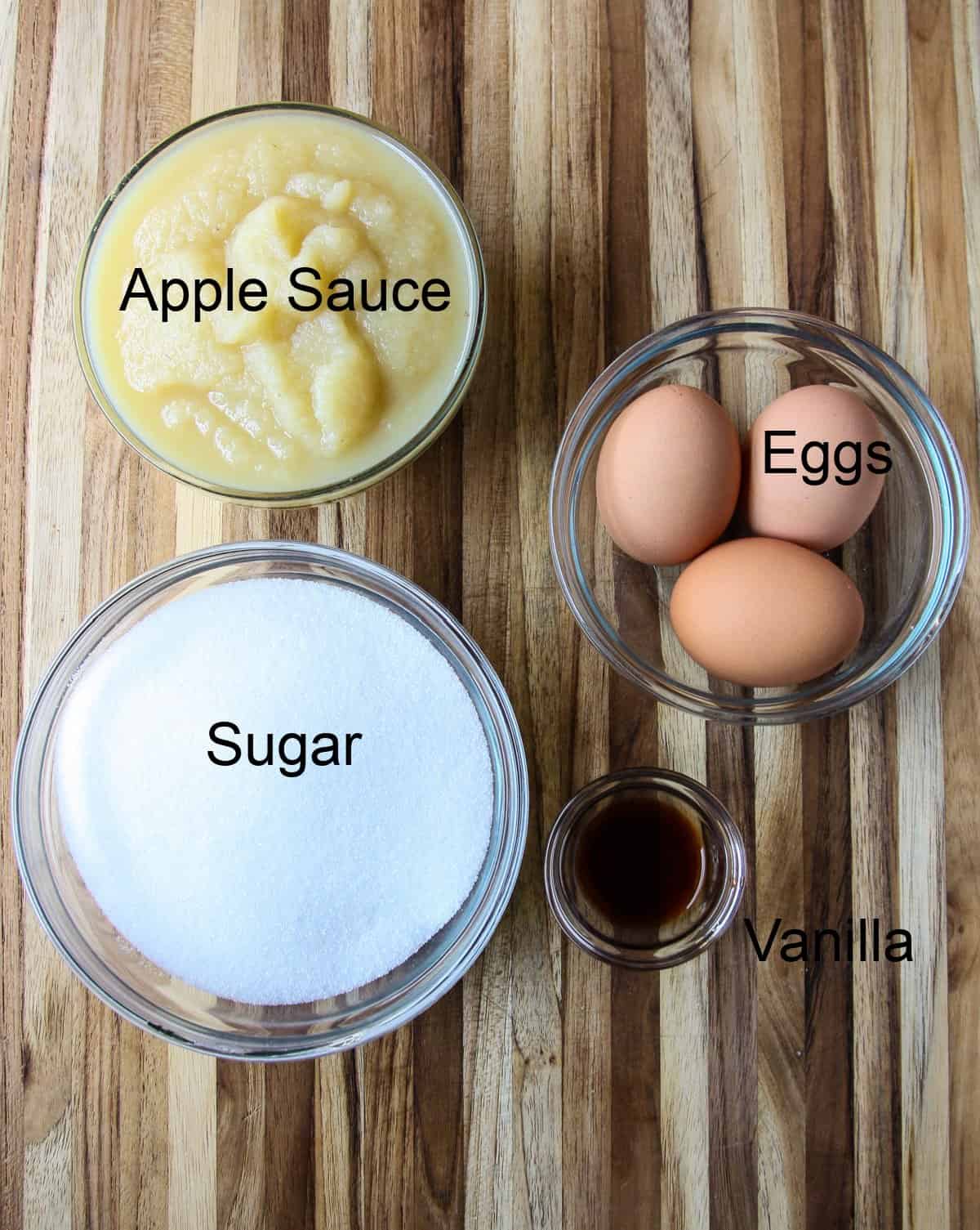 Sugar, eggs, and applesauce ingredients for cake.