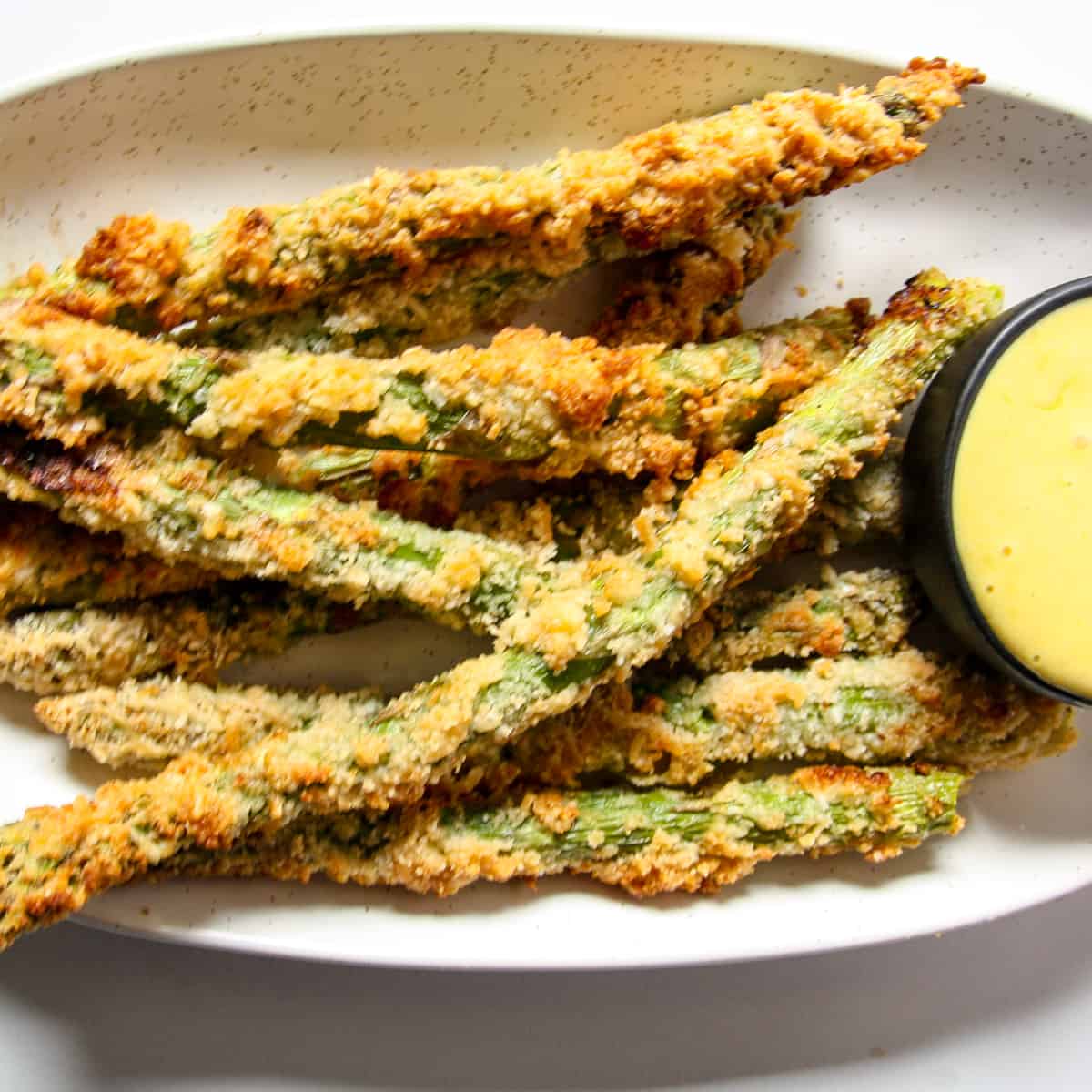 A close up of fried asparagus on a plate.