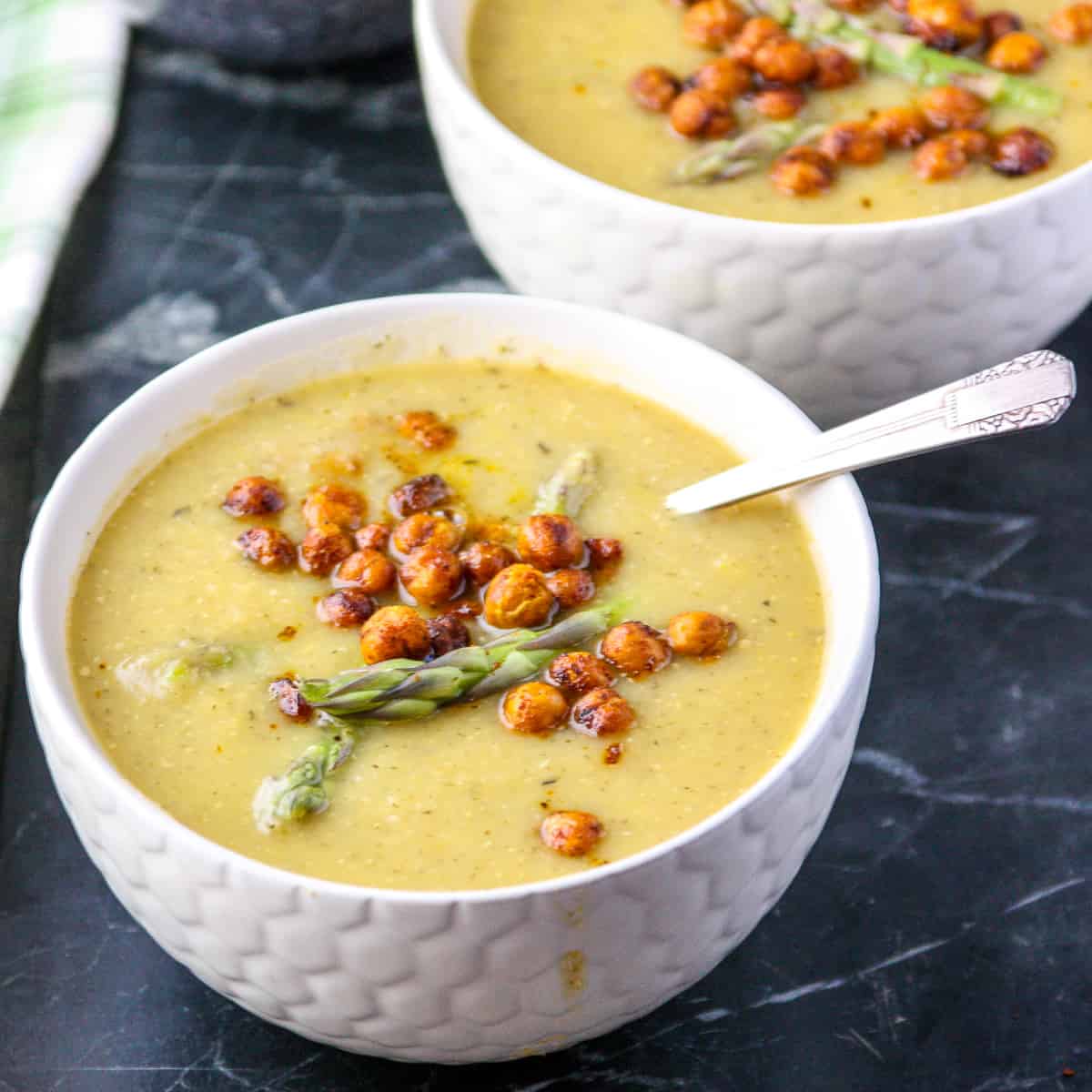 Vegan Asparagus Soup in a white bowl topped with roasted chickpeas.