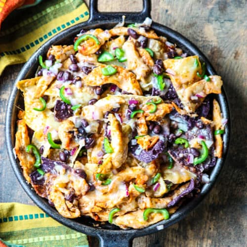 Baked nachos in a cast iron skillet.