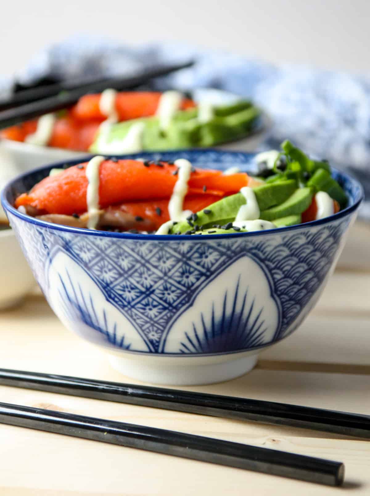 A blue and white bowl of rice and sushi ingredients.