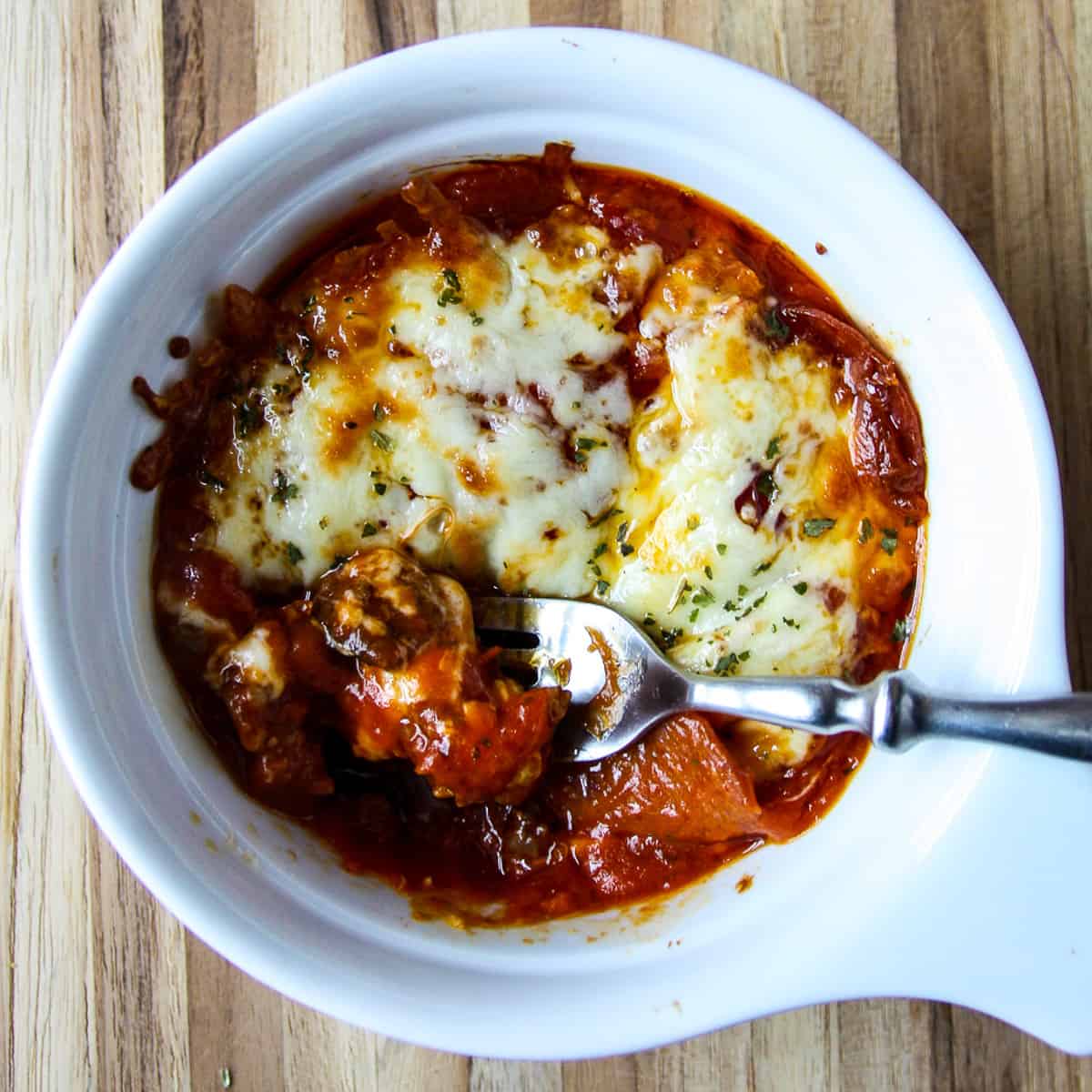A pizza bowl on a wooden cutting board.