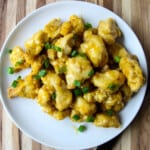 Air fried orange chicken garnished with green onions.
