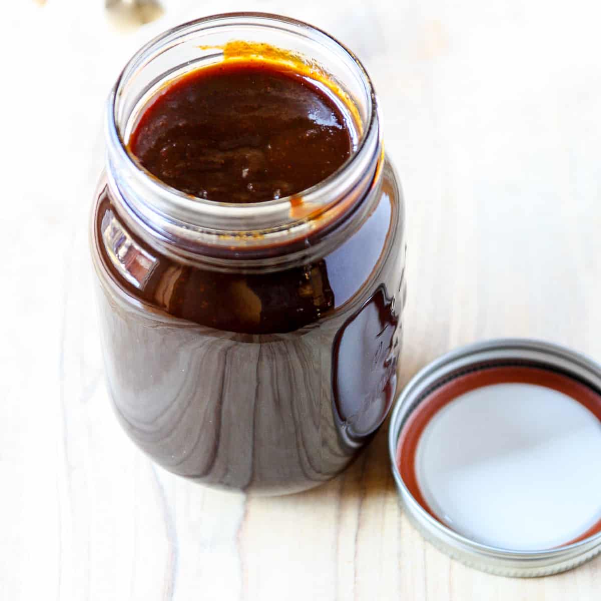 A mason jar filled with barbecue sauce.