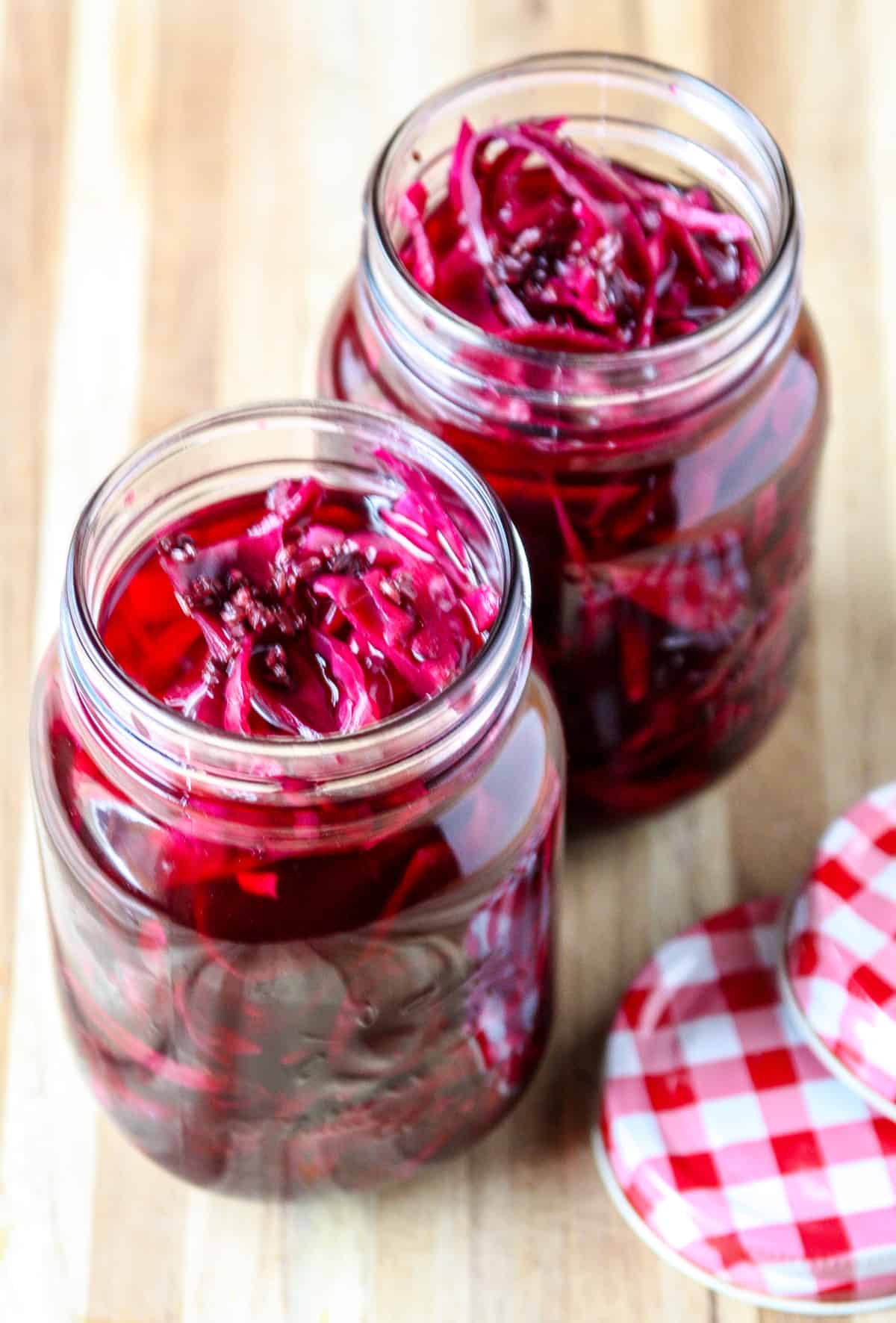 Two glass jars filled with pickled cabbage.