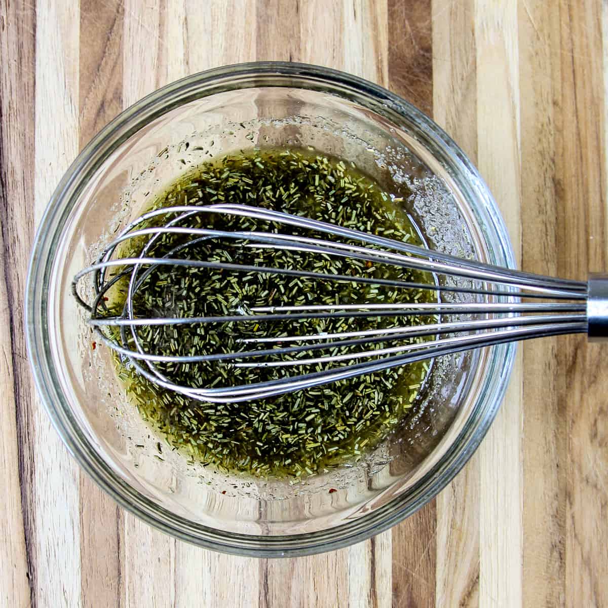 The marinade ingredients in a glass bowl being whisked together.