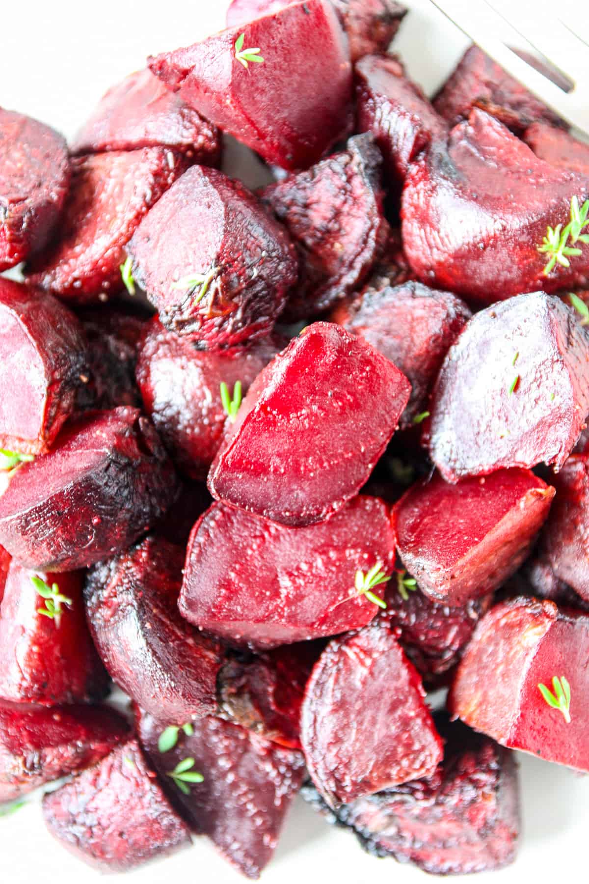 A close up of the roasted air fryer beets, garnished with fresh time leaves.