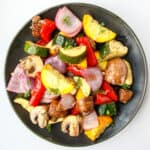 Air fryer roasted vegetables on a black plate.