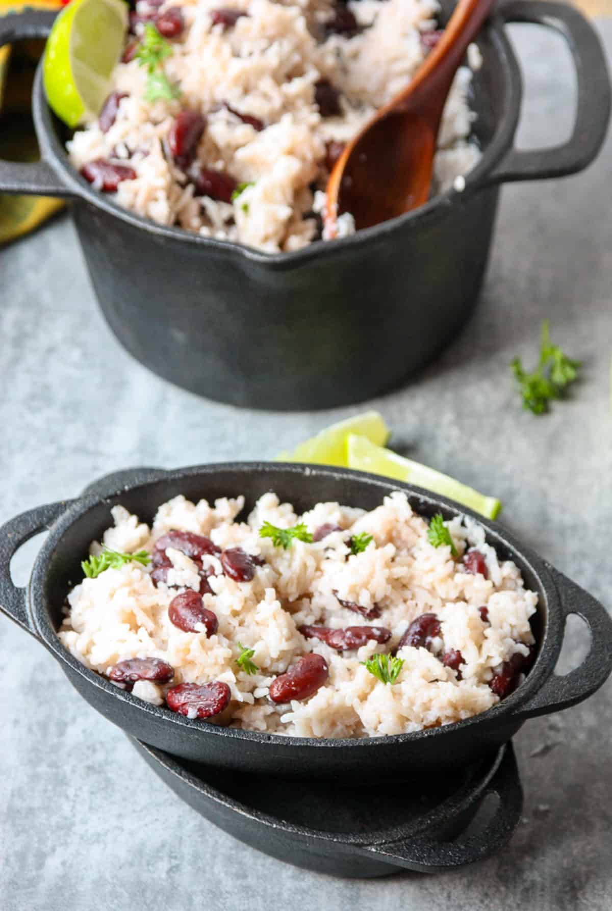 A pot of Jamaican rice and beans and two dishes.