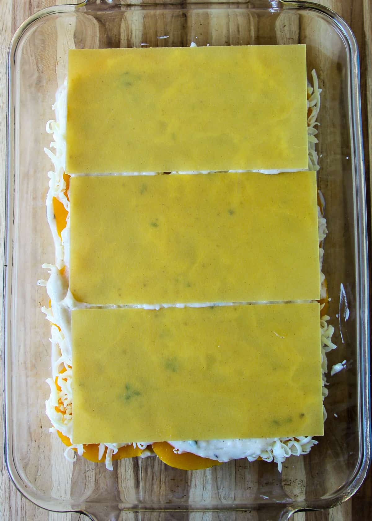 Another layer of uncooked lasagna noodles in the pan.