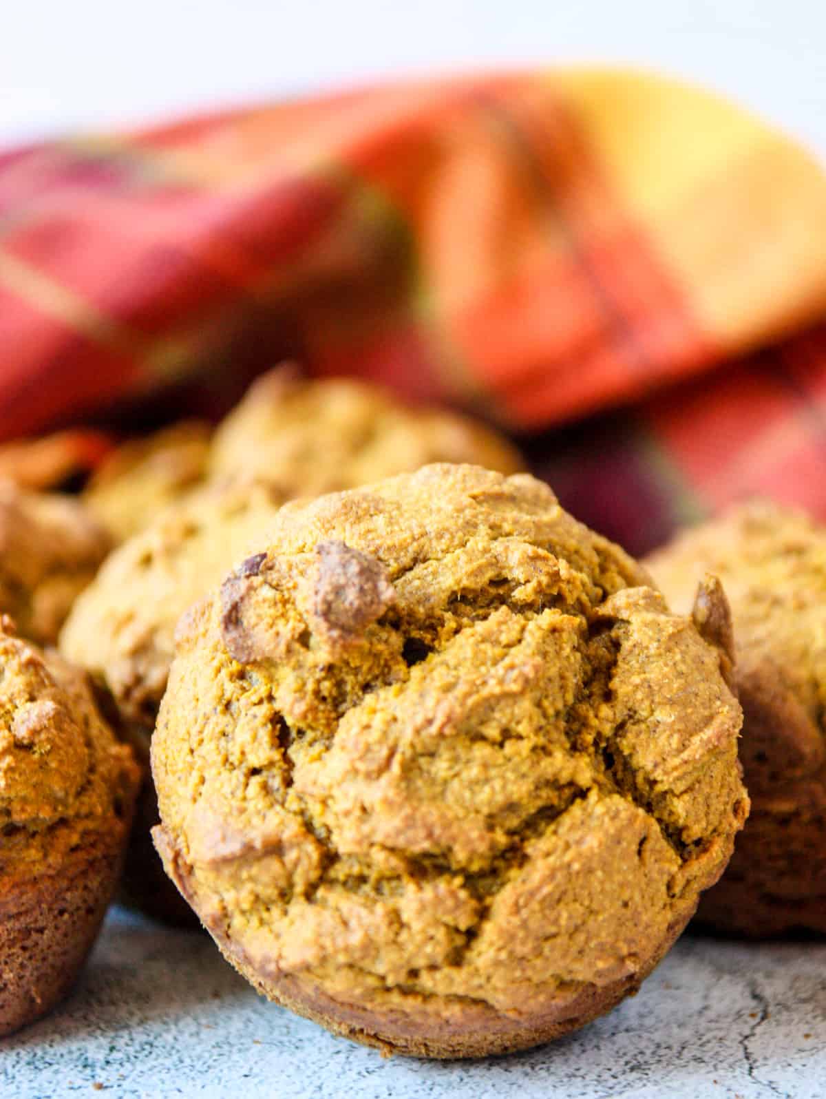 An oat flour pumpkin muffin on its side on a counter top.