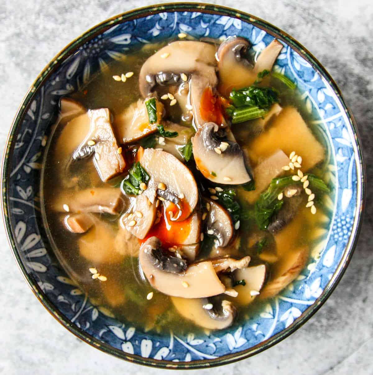 A blue and white bowl filled with miso mushroom soup.