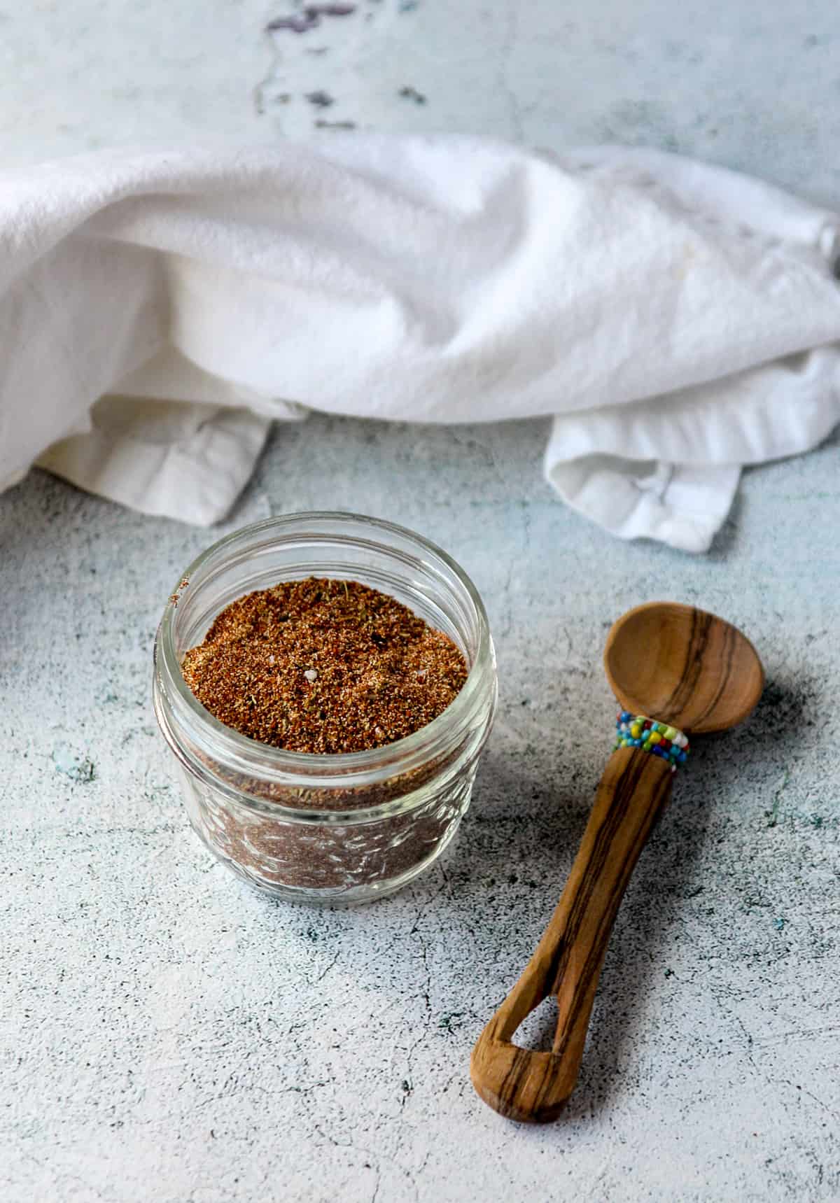 Chicken taco seasoning blend in a small mason jar on a stone countertop.