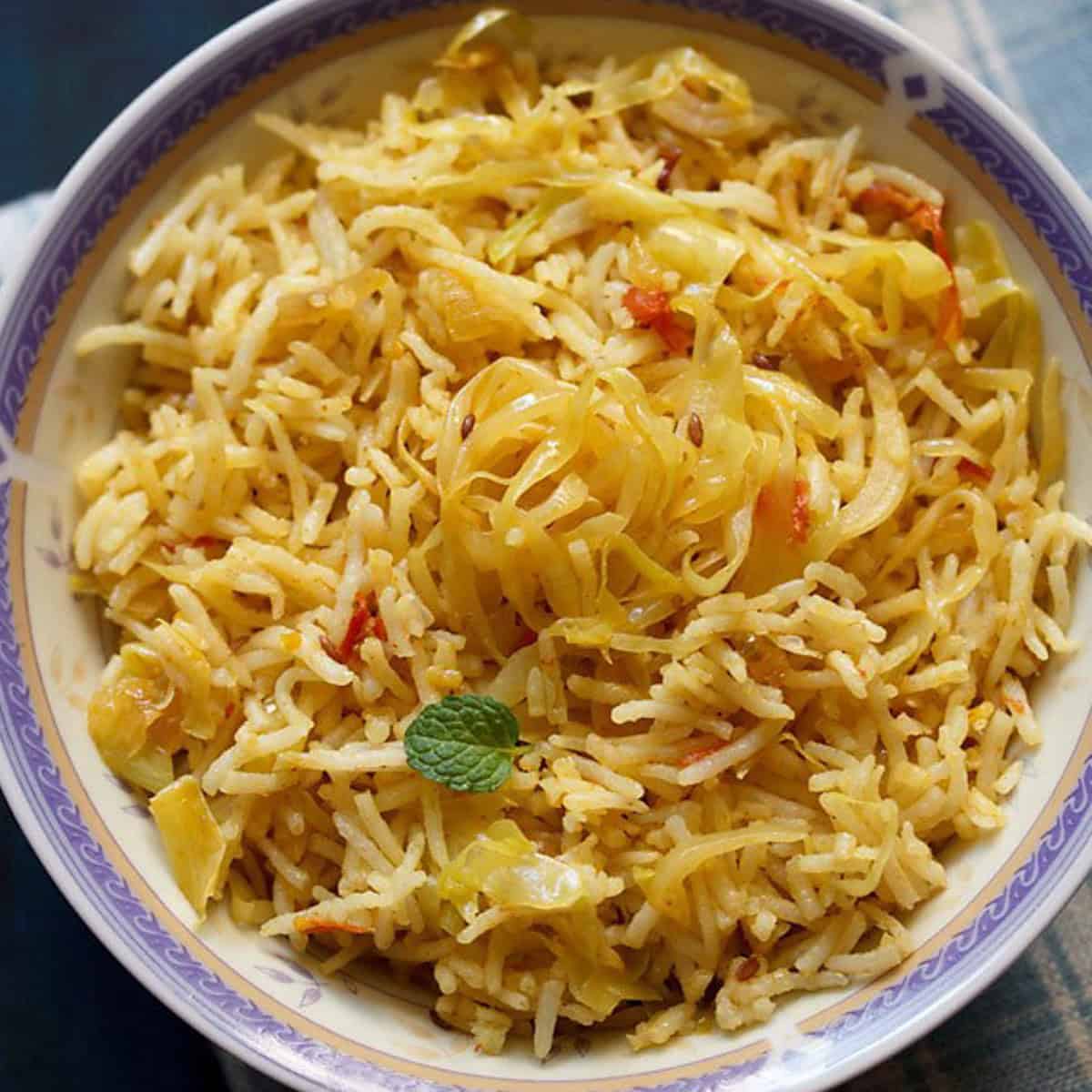 Cabbage fried rice in a blue and white bowl.