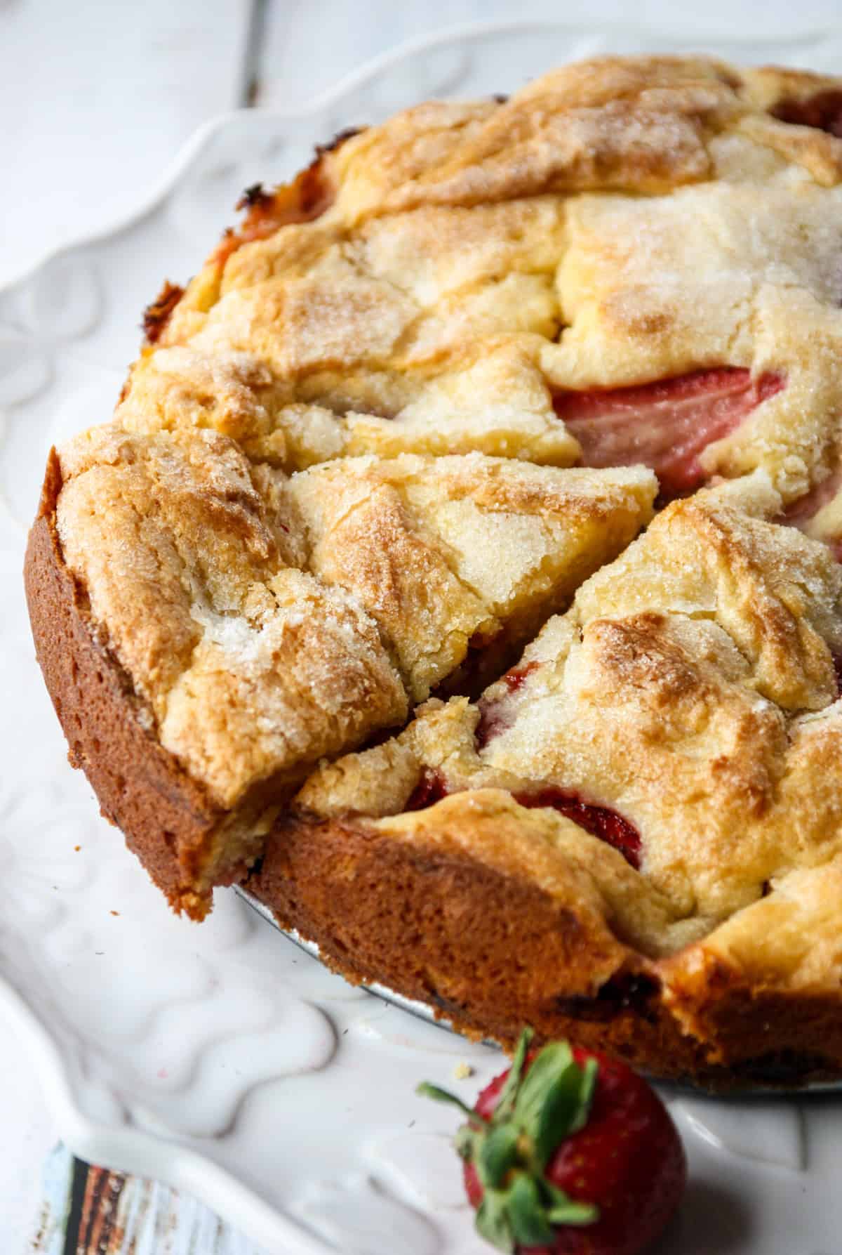 A baked French strawberry cake with a slice cut.