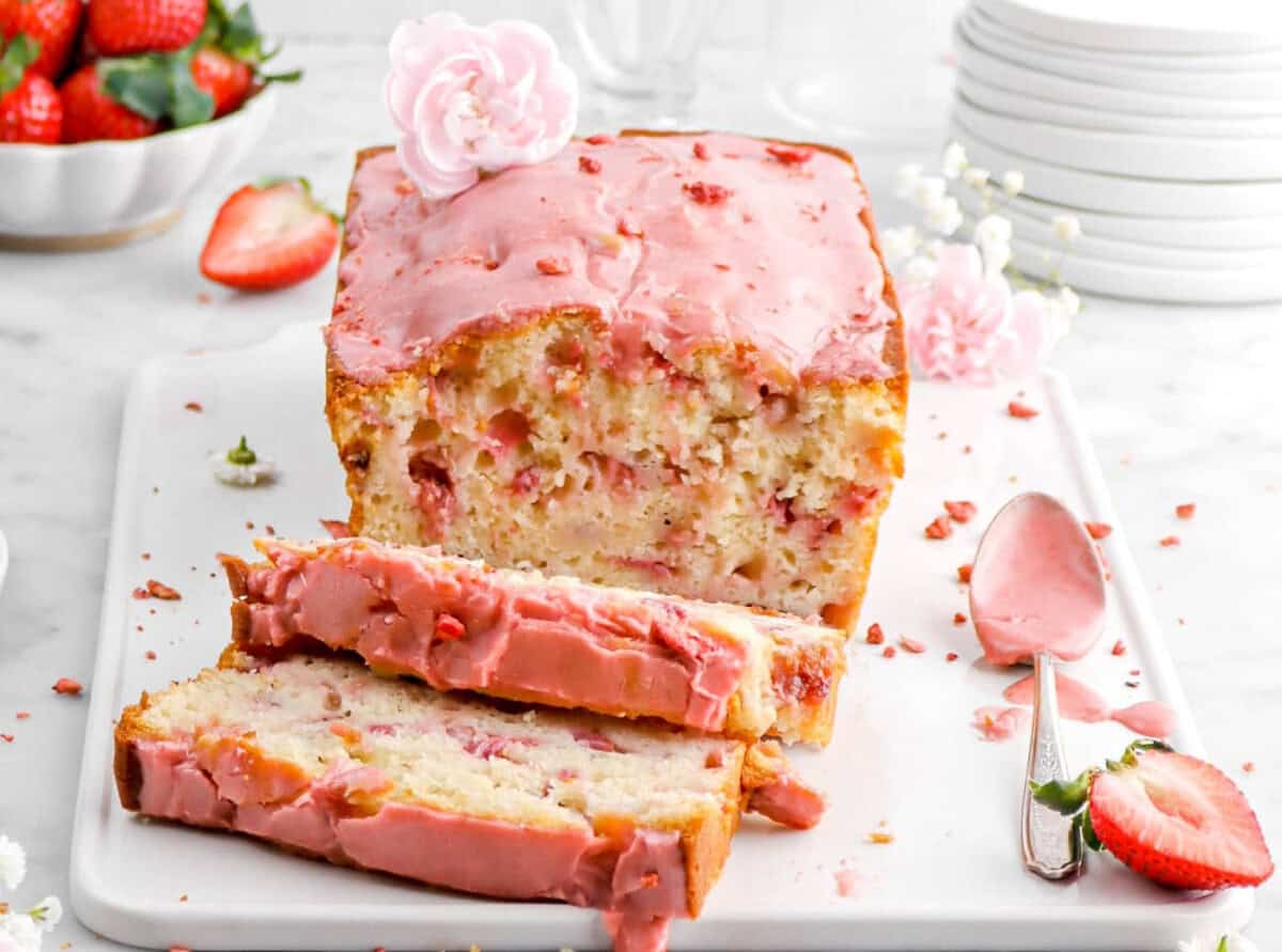 A loaf of strawberry bread with pink frosting.
